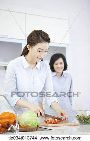 Picture - two woman cooking in the kitchen. Fotosearch