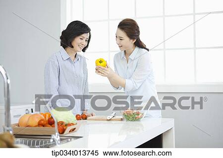 Stock Photography - two woman cooking in the kitchen. Fotosearch