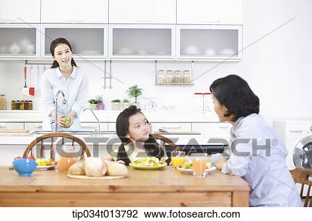 Stock Image - two women and a kid in the kitchen. Fotosearch