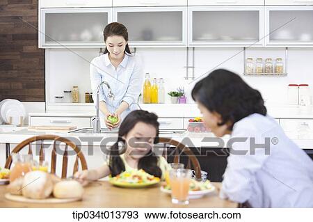 Stock Image - two women and a kid in the kitchen. Fotosearch
