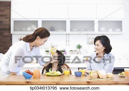 Stock Photography - two women and a kid in the kitchen. Fotosearch
