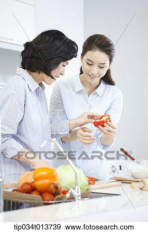 Stock Photo - two women cooking in the kitchen. Fotosearch
