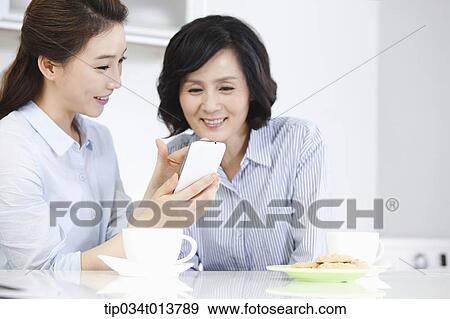 two women having cup of coffee in the kitchen View Large Photo Image Stock Photo - two women having cup of coffee in the kitchen. Fotosearch