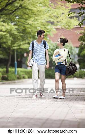Stock Image - university students walking in the campus talking . Fotosearch