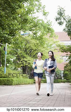 Stock Image - university students walking in the campus talking . Fotosearch