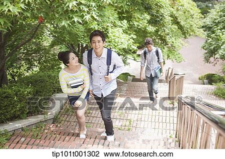 Stock Image - university students walking up the stairs together in the campus . Fotosearch