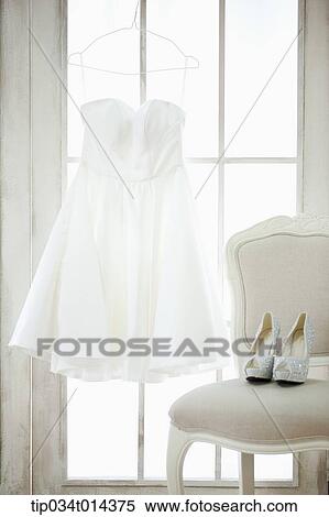 Stock Photography - wedding dress hanging in bride's room. Fotosearch