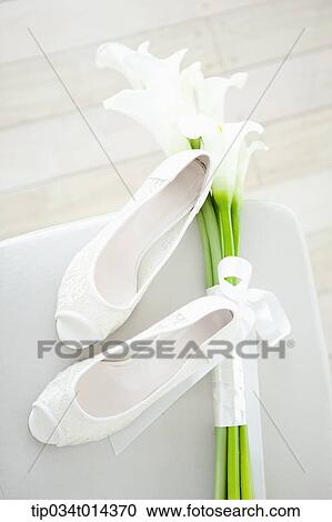 Stock Image - white heels and flowers . Fotosearch