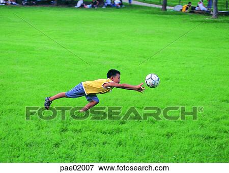 Stock Photo - child, action, soccer, ball, boys, boy, lawn. Fotosearch