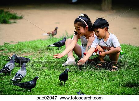 Stock Photo - child, animal love, human, bird, oriantal, human. Fotosearch