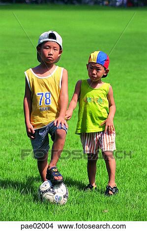 Picture - child, boy, brother, ball, ball play, soccer, lawn. Fotosearch