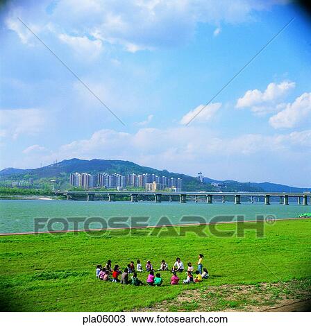 Stock Image - bridge, terrace land on the river, park, cloud, man and woman, men and women, male and female. Fotosearch