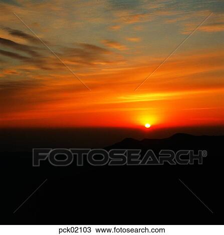 Stock Image - cloud, day, red sky, sunset, sunrise, ridgeline, outline. Fotosearch