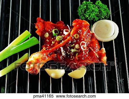 Stock Photography - roasted food, frenched hot and spicy chicken ribs served with vegetables, dakgalbi, roasted chicken leg dish, garlic, indoor. Fotosearch