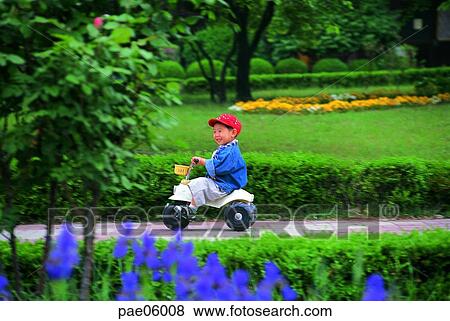 Stock Photo - three-wheels bicycle, riding a bike, riding a bicycle, children, child, kid, infant. Fotosearch