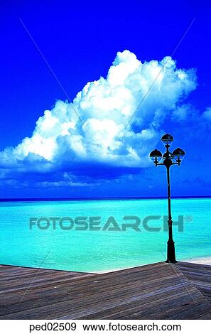 Stock Photo - street lamp, street light, cloud, cumulus, mass of cloud, sea. Fotosearch