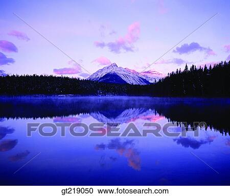 Stock Image - mountain, lake, mountaintop, peak, remaining snow, forest, trees. Fotosearch