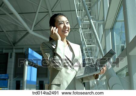 Stock Image - conversation, notebook, trainstation, airportcorridor, person, oriental. Fotosearch