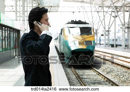 Stock Photograph - trainstation, business trip, conversation, person, oriental, Korean, Asian. Fotosearch