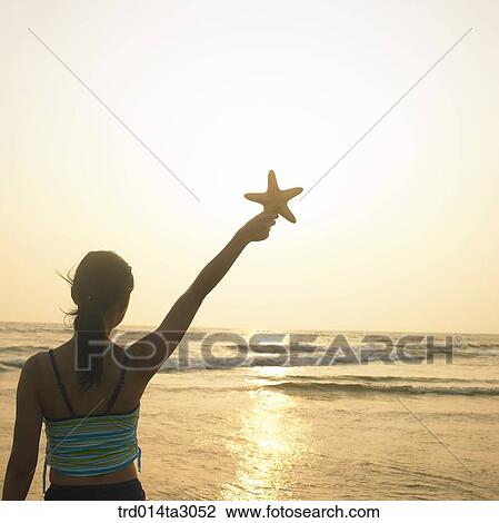 Stock Image - starfish, gesture, posture, silhouette, the setting sun, glow, person. Fotosearch