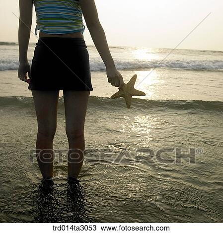 Stock Image - starfish, gesture, posture, silhouette, the setting sun, glow, body. Fotosearch