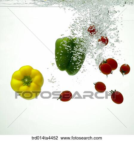 Stock Image - Green peppers and tomatoes in water. Fotosearch