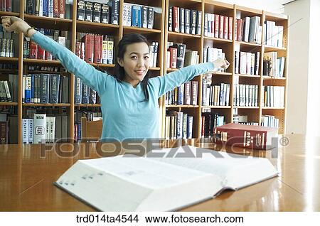 Picture - A girl studying in the library. Fotosearch