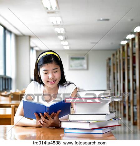 Stock Photo - A girl studying in the library. Fotosearch