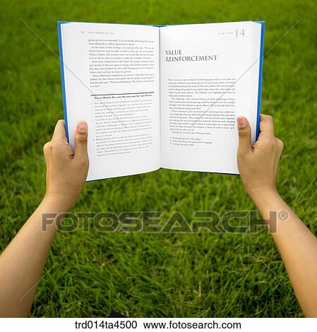 Stock Image - A hand holding a book. Fotosearch