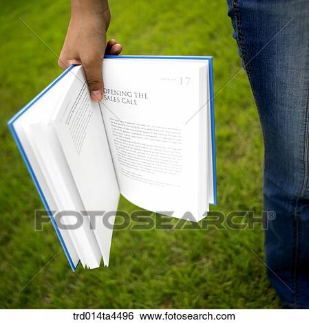 Stock Photograph - A hand holding a book. Fotosearch