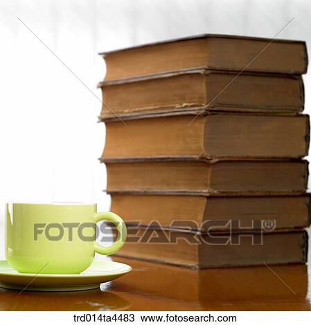 Stock Image - a heap of books and a cup. Fotosearch