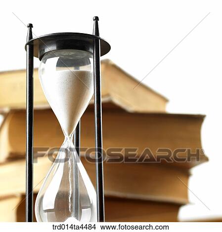 Picture - A heap of books and a sandglass. Fotosearch