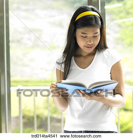 a woman reading a book beside the window View Large Photo Image Stock Image - a woman reading a book beside the window. Fotosearch