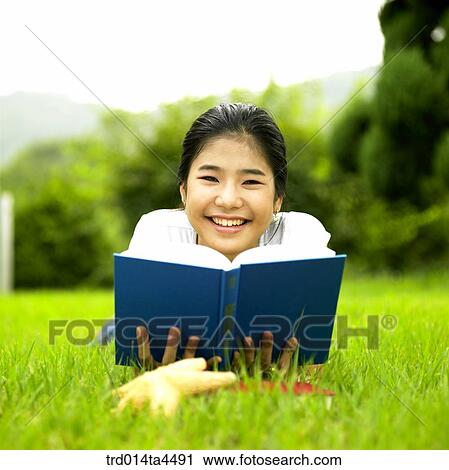 a woman reading a book on the grass View Large Photo Image Stock Image - a woman reading a book on the grass. Fotosearch