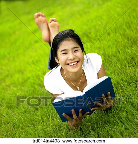 a woman reading a book on the grass View Large Photo Image Stock Image - a woman reading a book on the grass. Fotosearch