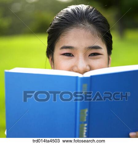 a woman reading a book on the grass View Large Photo Image Stock Image - a woman reading a book on the grass. Fotosearch
