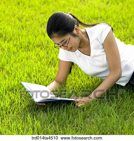 a woman reading a book on the grass View Large Photo Image Stock Image - a woman reading a book on the grass. Fotosearch