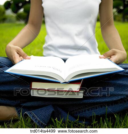 a woman reading a book on the grass View Large Photo Image Stock Photo - a woman reading a book on the grass. Fotosearch