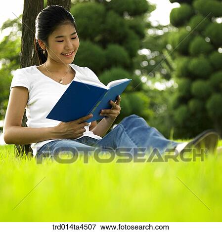 a woman reading a book on the grass View Large Photo Image Stock Photo - a woman reading a book on the grass. Fotosearch