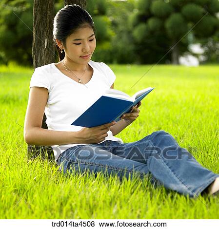 a woman reading a book on the grass View Large Photo Image Stock Photo - a woman reading a book on the grass. Fotosearch