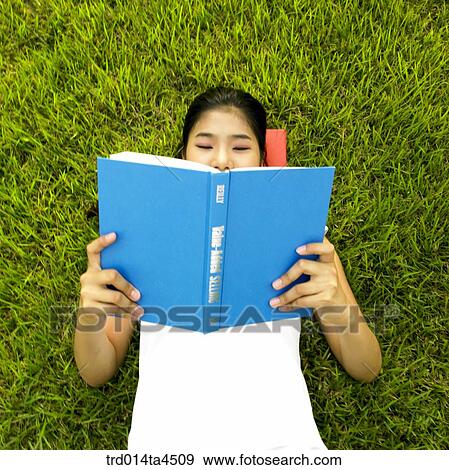 a woman reading a book on the grass View Large Photo Image Stock Photo - a woman reading a book on the grass. Fotosearch