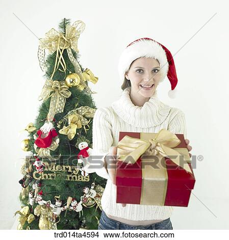 Picture - A woman holding a Christmas gift. Fotosearch