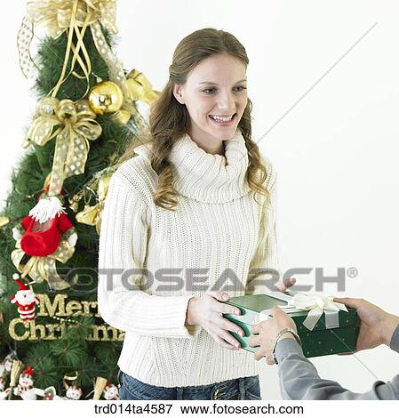 Stock Photo - A woman receiving a Christmas gift. Fotosearch