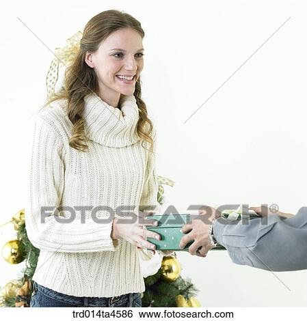 Stock Photograph - A woman receiving a Christmas gift. Fotosearch