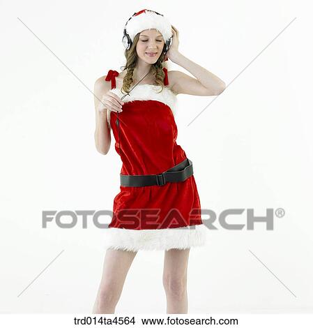 A woman wearing Santa Claus' clothes and listening to music View Large Photo Image Picture - A woman wearing Santa Claus' clothes and listening to music. Fotosearch