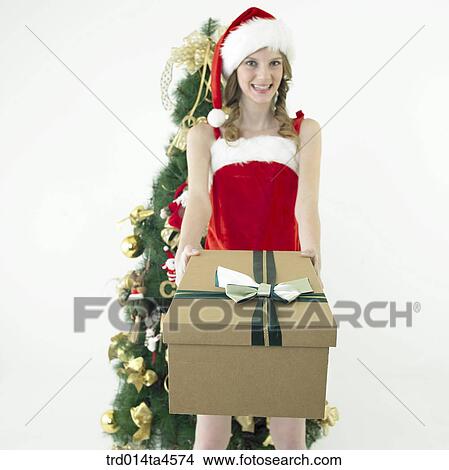 Picture - a woman wearing Santa Claus' clothes and giving gifts. Fotosearch
