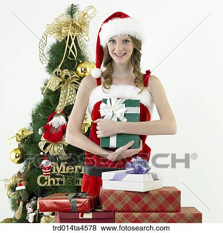 Stock Photo - a woman wearing Santa Claus' clothes and giving gifts. Fotosearch
