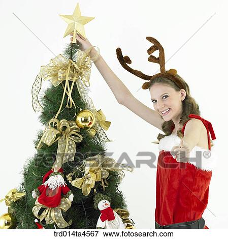 Stock Photo - Christmas decoration and a woman wearing Santa Claus' clothes. Fotosearch