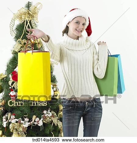 Christmas Tree, a woman holding a shopping bag View Large Photo Image Stock Image - Christmas Tree, a woman holding a shopping bag. Fotosearch