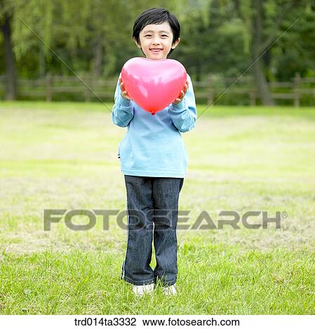 boy holding heart shaped ballon View Large Photo Image Stock Image - boy holding heart shaped ballon. Fotosearch